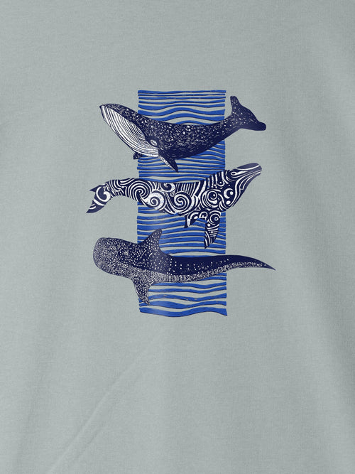 Light blue ZOE T-shirt with three artistic whale prints and blue wave background, Greek cotton