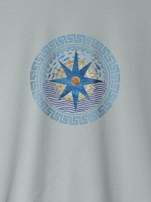 Light blue ZOE T-shirt with Greek-inspired compass and wave art design on chest