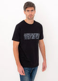 Man wearing ZOE black T-shirt with abstract Greek art pattern, crafted from Greek cotton